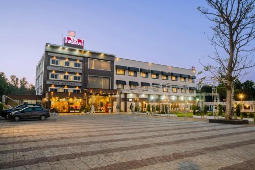 un grand bâtiment avec un parking en face de celui-ci dans l'établissement Hotel Vasdaa Grand, à Dehradun