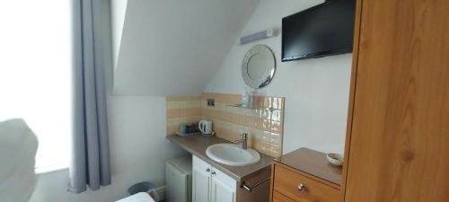 La salle de bains est pourvue d'un lavabo et d'un miroir. dans l'établissement Invernook, à Newquay
