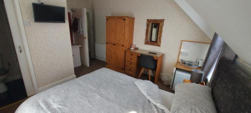 a small bedroom with a bed and a desk at Invernook in Newquay