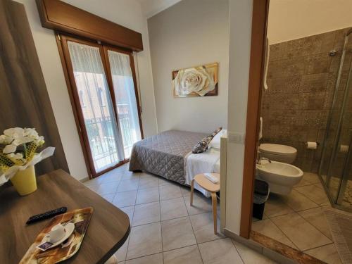 a bedroom with a bed and a bathroom with a tub at Hotel Villa Fulgida in Cattolica