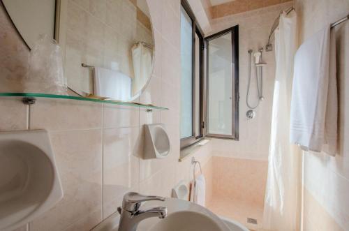 a bathroom with a sink and a toilet and a window at Hotel Del Buono Wellness & Medical Spa in Chianciano Terme