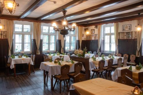 ein Esszimmer mit Tischen, Stühlen und Fenstern in der Unterkunft Hotel Bleske im Spreewald in Burg