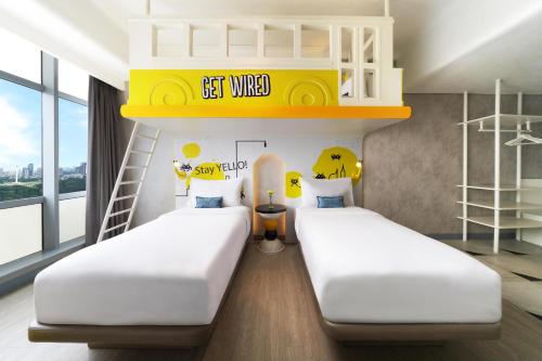 two beds in a room with a bunk bed at YELLO Hotel Harmoni in Jakarta