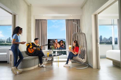a group of people in a living room playing music at YELLO Hotel Harmoni in Jakarta