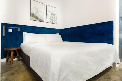 a large bed in a room with a blue wall at Limehome Lisbon Calçada do Cardeal in Lisbon