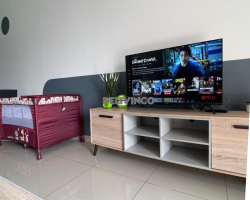 a large flat screen tv on a wooden entertainment center at Comfy 2 bedroom for 6 pax, 3mins walk to Kamalinda in Shah Alam