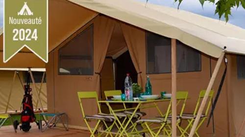 a tent with a table and chairs in front of it at Tente Lodge Safari - La Plage Autet in Autet