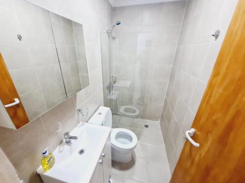 a white bathroom with a toilet and a sink at Departamentos temporarios Rg in Río Grande