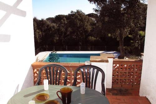 a table and chairs on a patio with a swimming pool at Mas Mundo - 4 Ferienhäuser in Calonge / Girona in Girona