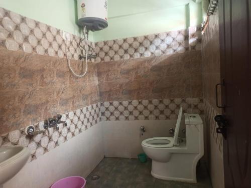 een badkamer met een toilet en een wastafel bij Badrinath Govindghat Prithvi yatra hotels in Badrīnāth