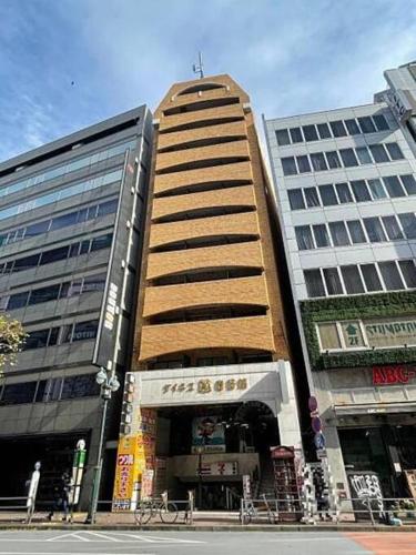 un edificio alto en una ciudad con dos edificios altos en Dynastshibuya涩谷一番館 en Tokio
