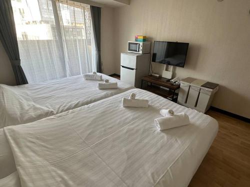Habitación de hotel con 2 camas y TV de pantalla plana. en Dynastshibuya涩谷一番館 en Tokio