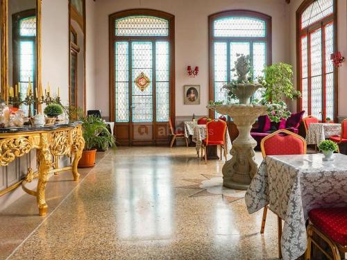 ナルボンヌにあるChâteau de La Pradeのテーブルと花瓶が備わる広い客室です。