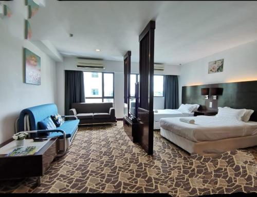 a large hotel room with two beds and a couch at Kk homeStay City suites Room Ming Garden Residence in Kota Kinabalu