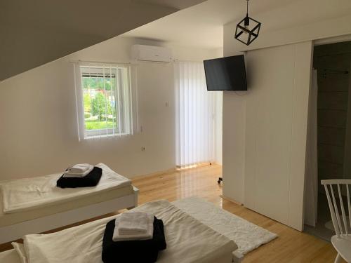 a white room with two beds and a window at Sobe Zizi in Jajce