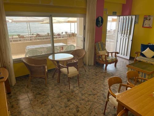 una sala da pranzo con tavolo, sedie e vista sull'oceano di Broadway es Mar a El Perelló