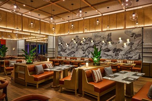 a restaurant with tables and chairs and a mural at W Taipei in Taipei