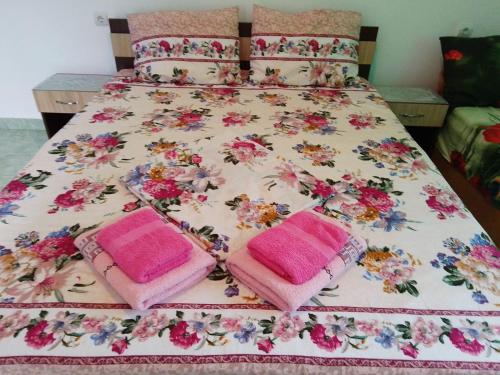 a bed with pink and pink towels on it at Casa Tonia in Douăzeci şi Trei August