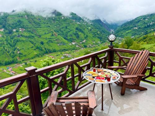 einen Tisch und Stühle auf einem Balkon mit Blick auf das Tal in der Unterkunft RizeHayatburdabungalov in Ardeşen