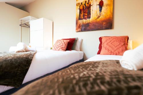 a bedroom with two beds and a painting on the wall at Lets Relax - Terre d'Afrique in Mons