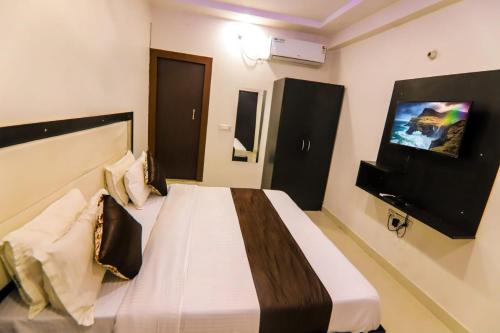 a bedroom with a bed and a flat screen tv at Hotel The Elite Inn in Agra