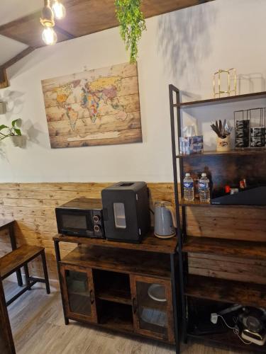 a room with a desk with a microwave and a tv at Two-Bedroom Cosy Country Lodge with Private Patio in Greenhithe