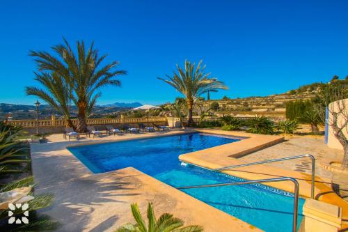 una piscina in un resort con palme di Villa Casa Cansala by Abahana Villas a Teulada