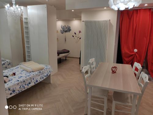 Zimmer mit einem Tisch und einem Bett sowie einem Tisch und Stühlen in der Unterkunft Romantic house posto auto aria condizionata in Bologna