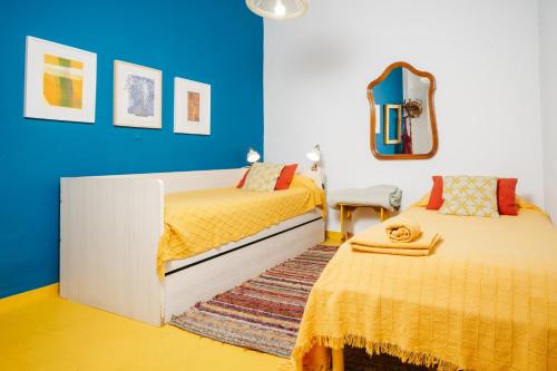 ein Schlafzimmer mit zwei Betten und einem Spiegel in der Unterkunft Tu estancia perfecta en Sevilla in Sevilla