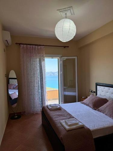 a bedroom with a large bed and a large window at Levi's Villa Radhima in Vlorë