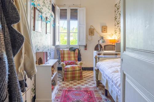 1 dormitorio con cama, escritorio y silla en Tía Angelina, Hogar Noucentista en Sant Hilari Sacalm