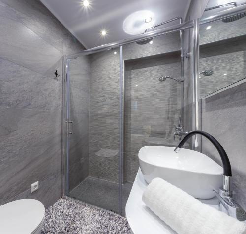 uma casa de banho com um chuveiro, um lavatório e um WC. em Hvar Pavičić Top View apartments em Hvar