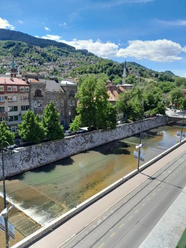 eine Brücke über einen Fluss in einer Stadt in der Unterkunft Intensa Emozione Sarajevo in Sarajevo