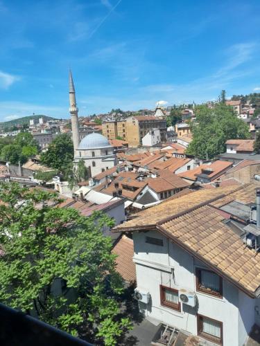 Blick auf eine Stadt mit einer Moschee und Dächern in der Unterkunft Intensa Emozione Sarajevo in Sarajevo