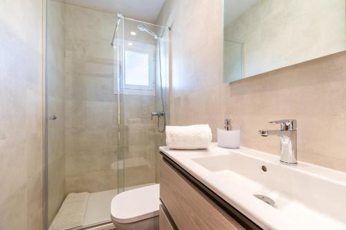 een badkamer met een douche, een wastafel en een toilet bij Apartamento Minerva in Alcudia