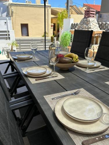 a wooden table with plates and wine glasses on it at Villa Massari in Haraki
