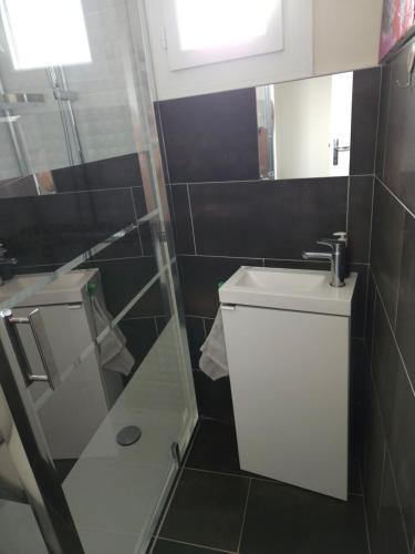 ein Badezimmer mit einem WC, einem Waschbecken und einem Spiegel in der Unterkunft Une chambre chez Christina 250m de la plage in Royan