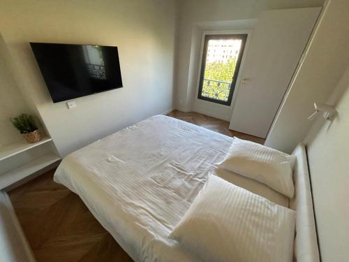 Habitación blanca con cama y TV en Vue magnifique, en Niza