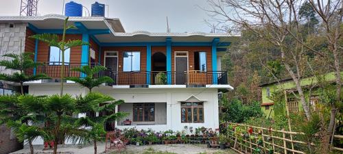 une maison bleue et blanche dans l'établissement AASHRAYA HOMESTAY, à Paten