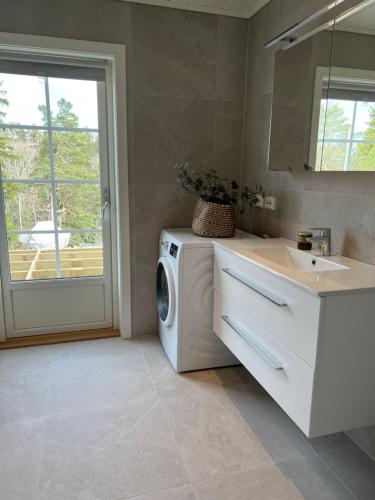 ein Badezimmer mit einer Waschmaschine und einem Waschbecken in der Unterkunft Hytteperle in Risør