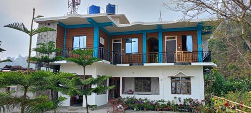 une maison avec un balcon et des palmiers dans l'établissement AASHRAYA HOMESTAY, à Paten