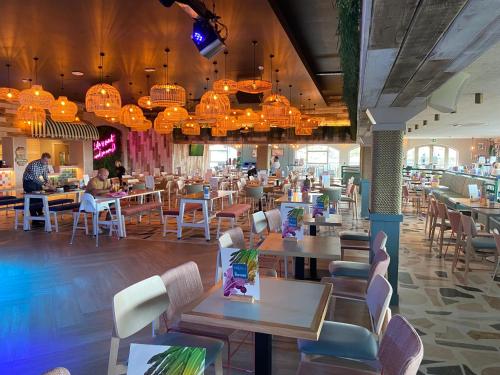 a restaurant with tables and chairs and people sitting at tables at 3 bedroom caravan on luxury Devon Holiday Park in Paignton