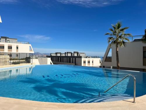 una gran piscina en la parte superior de un edificio con una palmera en Super con gran terraza y vistas, en Gran Alacant