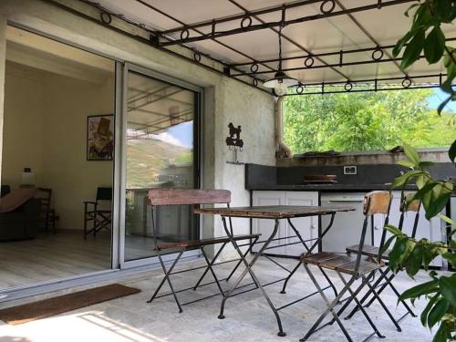 une cuisine avec une table et des chaises dans une pièce dans l'établissement Maison authentique corse, à Manso