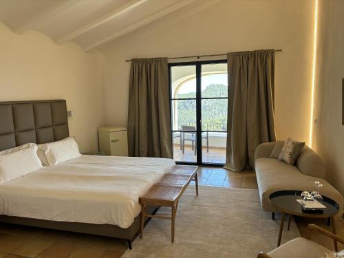 エスポレスにあるPosada del Marqués - bed & breakfastのベッドルーム1室(ベッド1台、ソファ、窓付)