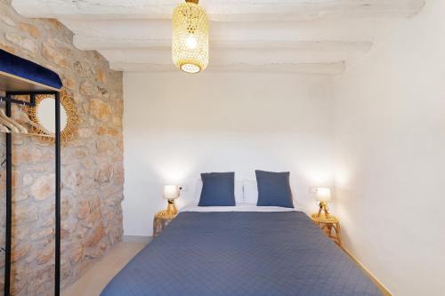 a bedroom with a bed and a stone wall at Mas Françó in Igualada