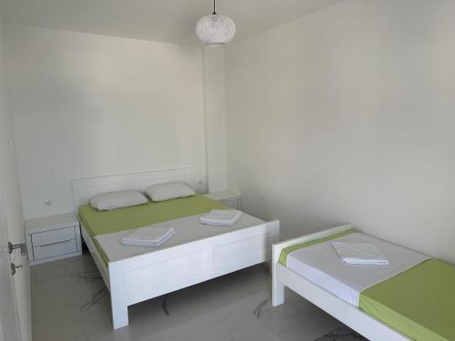 a white room with two beds and a table at Apartmani Sunce in Bar
