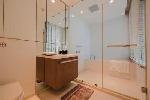 a bathroom with a shower and a sink and a toilet at Elegant 2-Bedroom Luxury Duplex on the 32nd floor of 185 Rajadamri in Bangkok