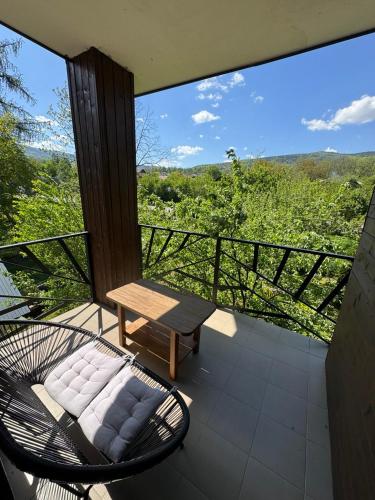a patio with a bench and a table on a balcony at Girske Povitria 2 in Yaremche