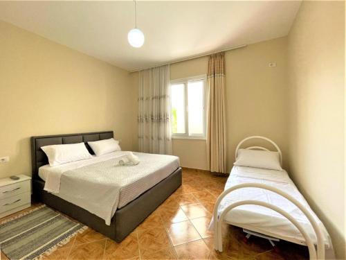 1 dormitorio con 2 camas y ventana en Villa Allegri en Vlorë